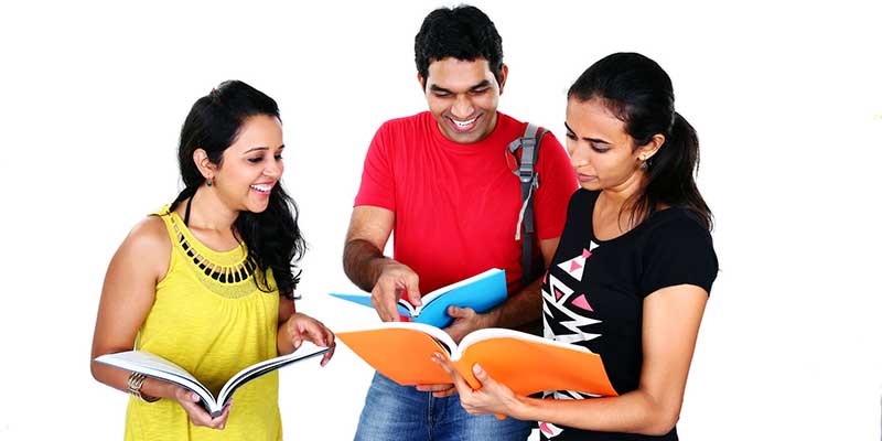 Two female and one male friend smiling and studying