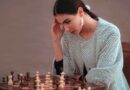 Woman thinking while playing chess