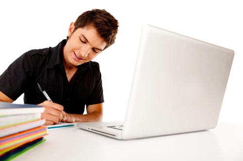 Happy male student with a laptop and notebooks