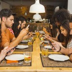 Group of friends at a restaurant occupied with cell phones