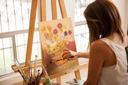 Female artist giving finishing touches to her painting