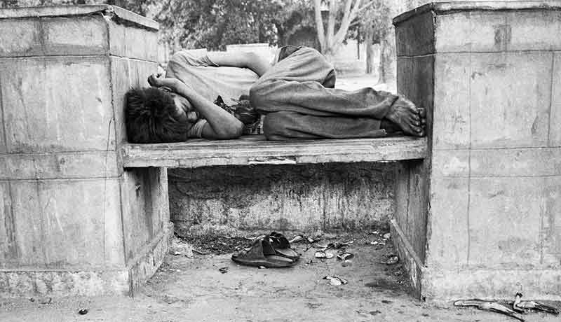 Street child sleeping on a street bench