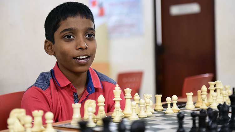 Praggu sitting in front of a chess board