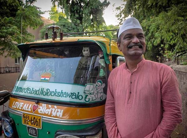Udaybhai standing near his rickshaw