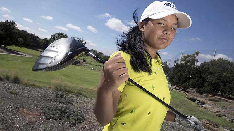 Pratima Sherpa carrying a golf club