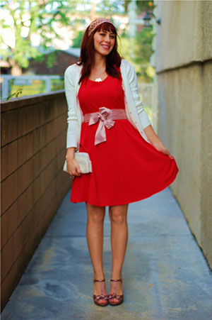 Young woman wearing red skater dress with white cardigan/shrug