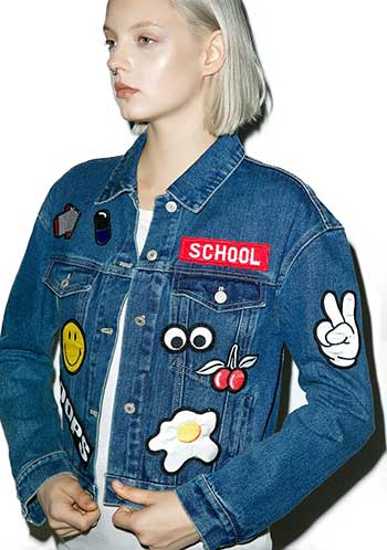 Young woman wearing denim jacket with patches