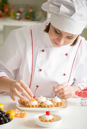 Female confectioner-chef icing cupcakes