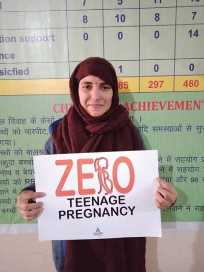 Roshni Bairwa holding up a Zero Teenage Pregnancy sign
