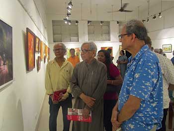 Eminent artist Ganesh Haloi (second from right) evaluating Manoj’s painting at an exhibition.