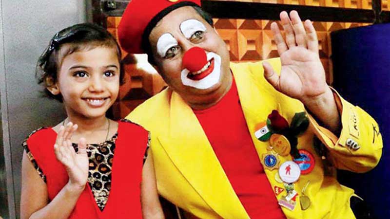 Pravin Tulpule dressed as a clown cheering up a small girl