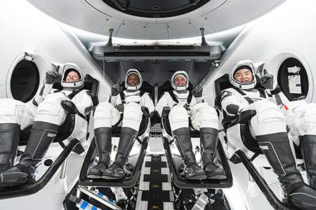 NASA’s SpaceX Crew-1 crew members are seen seated in the company’s Crew Dragon spacecraft during crew equipment interface training.