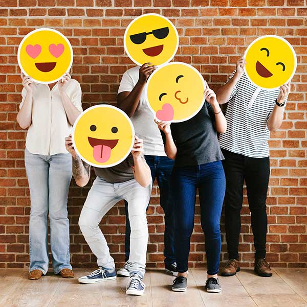 Teenagers holding up various emoticons