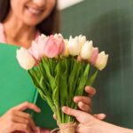 Student gifting flowers to teacher on Teachers' Day