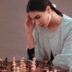 Woman thinking while playing chess