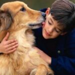 Young boy hugging his pet dog
