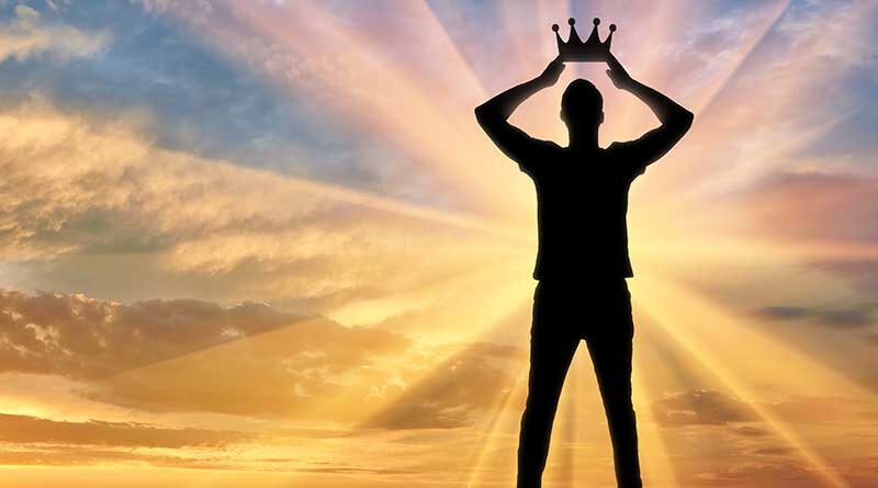 Silhouette of a man holding a crown above his head