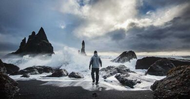 Man walking on seashore in stormy weather