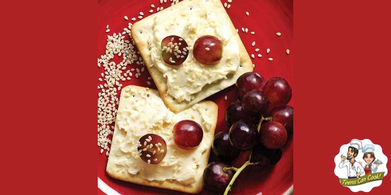 Cream Crackers with cheese, mayonnaise and grapes on them