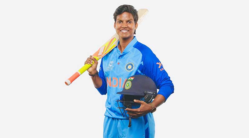 Deepti Sharma holding her cricket bat and helmet.